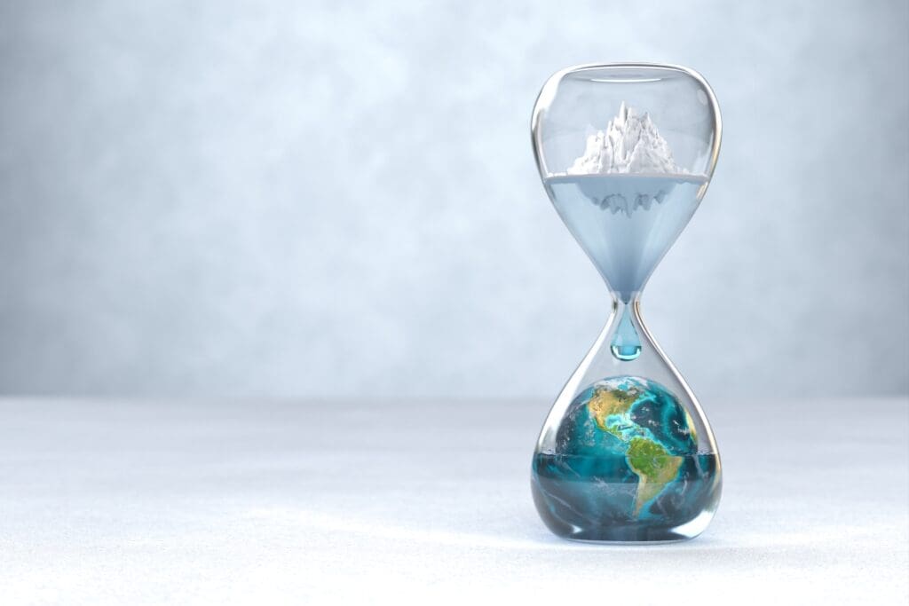 Hourglass with Earth inside with an glacier melting above - global warming concept (s. climate anxiety)