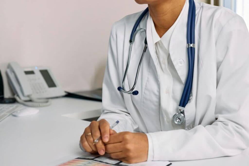 A Woman (doctor) in White Coat Sitting at the table (healthcare, climate)