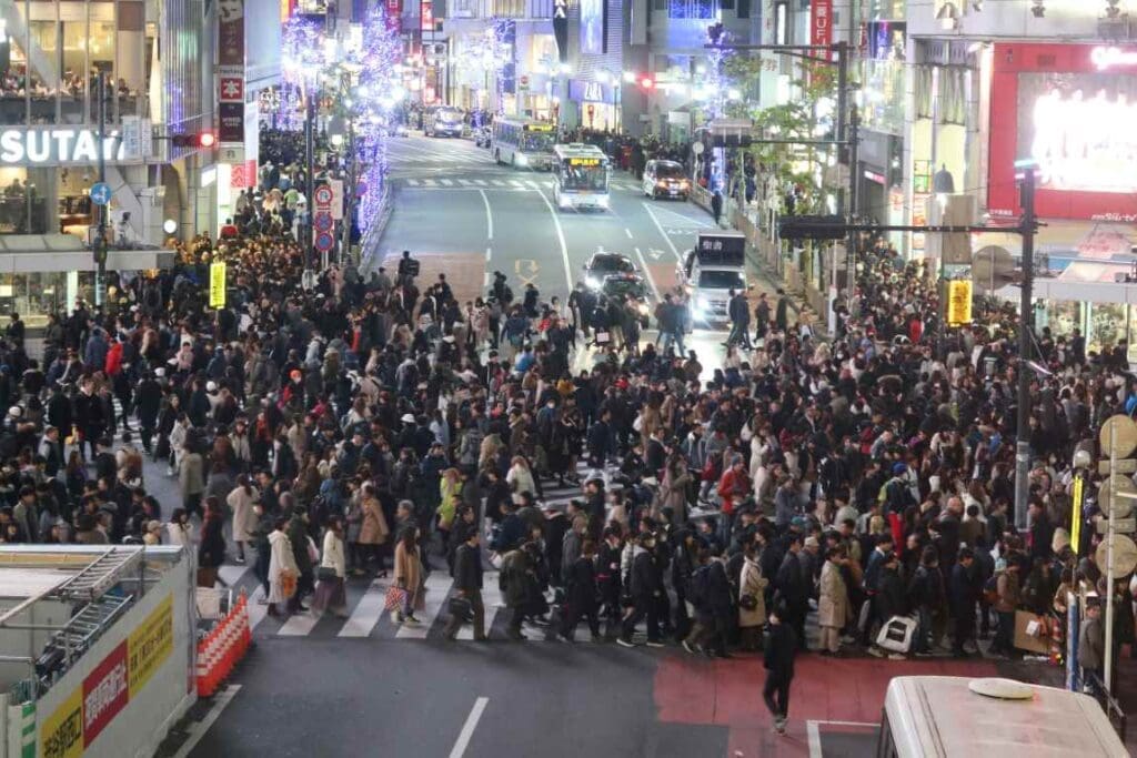 Large group of people walking across a street (s climate, environment, taxes)
