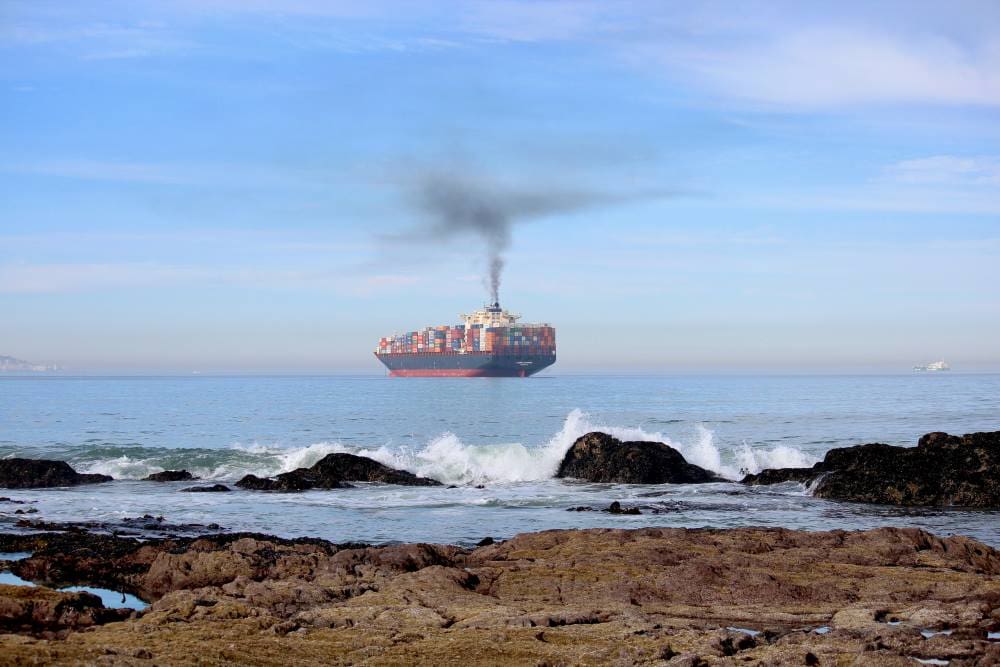 Image: a large cargo ship in the middle of the ocean (s. maritime emissions)