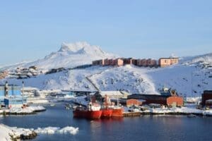 Home Image: red and white ship on sea near mountain (s. Nuuk, Greenland)