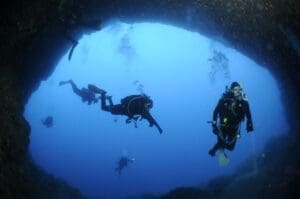 Home Image: a group of divers swimming in a cave