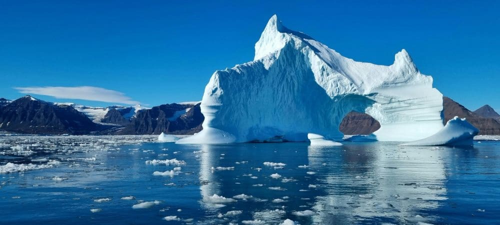 Home Image: Iceberg on body of water under blue sky