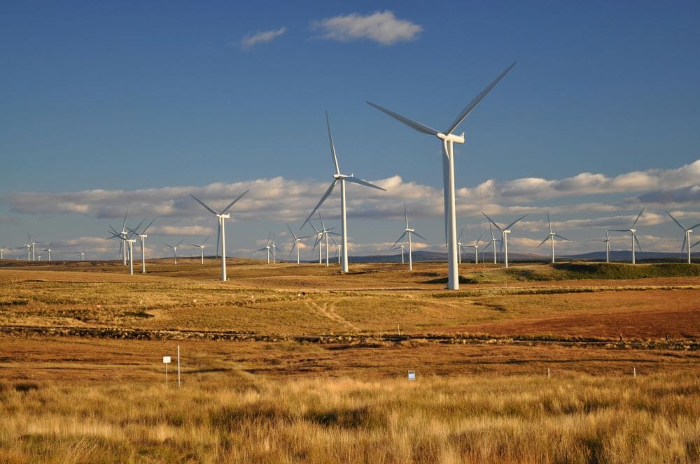 Image: White Windmills Under a Blue Sky - Eaglesham, Scotland, United Kingdom (s. clean energy)