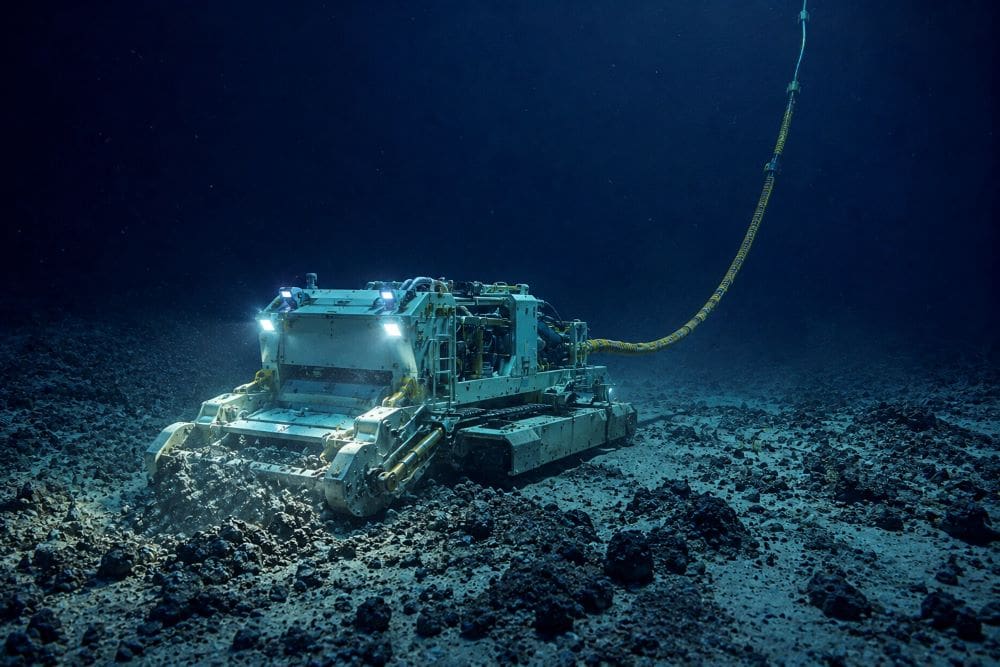 Image: Illustration of an uncrewed deep-sea mining machine operating on the seabed, connected by a cable to a surface vessel above while disturbing sediment on the ocean floor (AI-Generated)