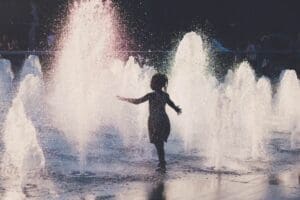 Home Image: girl cools off in a water fountain