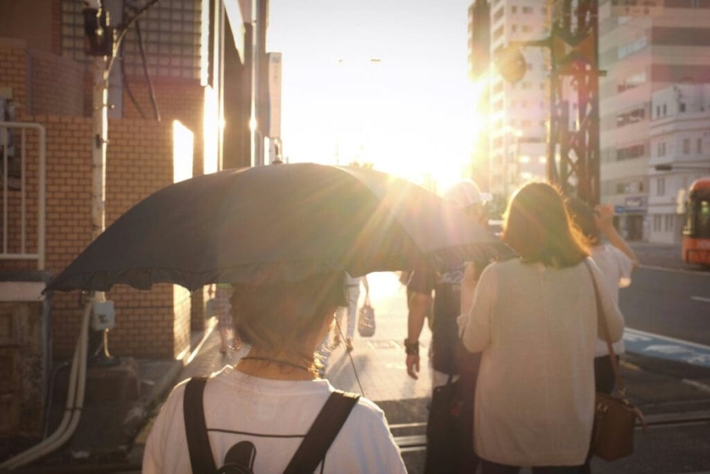 Home Image: woman in white shirt holding umbrella in a sunny day