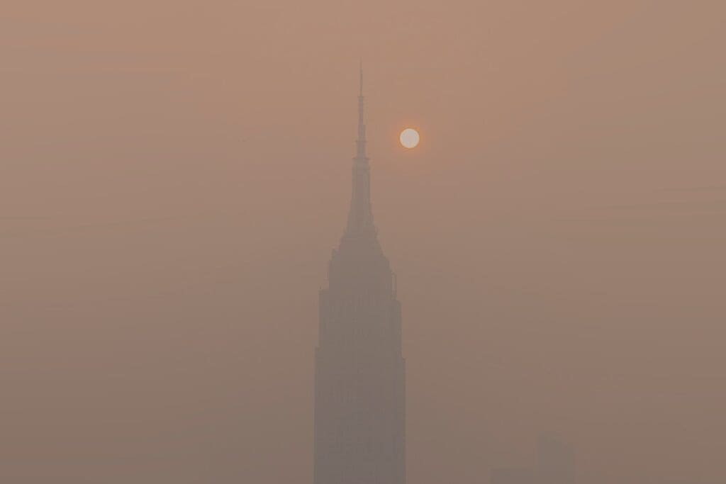 Image: a foggy skyline with a tall building in the distance