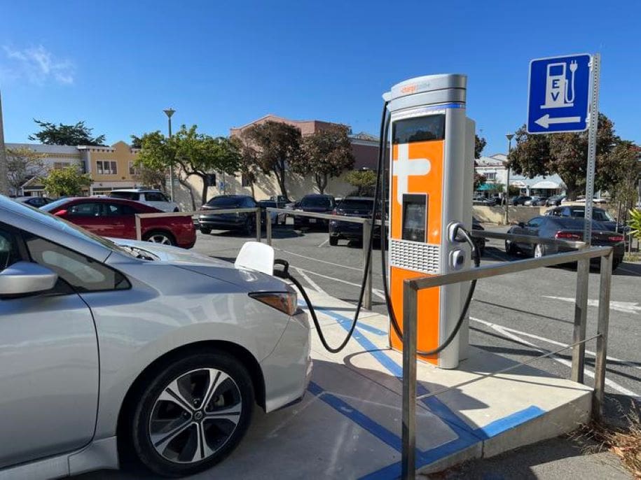 Home Image: An electric vehicle plugged in at a public fast-charge station in Pacific Grove, California (s. cars, emissions)