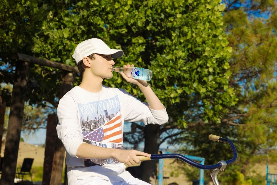 Home Image: Cyclist drinking water outdoors during hot weather