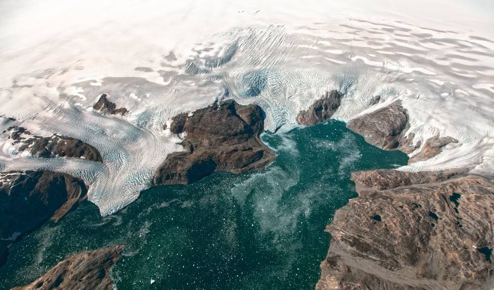 Home Image: Aerial view of glaciers flowing into the turquoise waters of Johan Petersen Fjord in southeastern Greenland