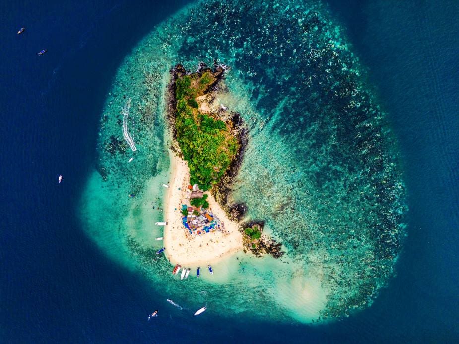 Image: Aerial view of an island off Phuket, Thailand, surrounded by turquoise waters and coral reefs